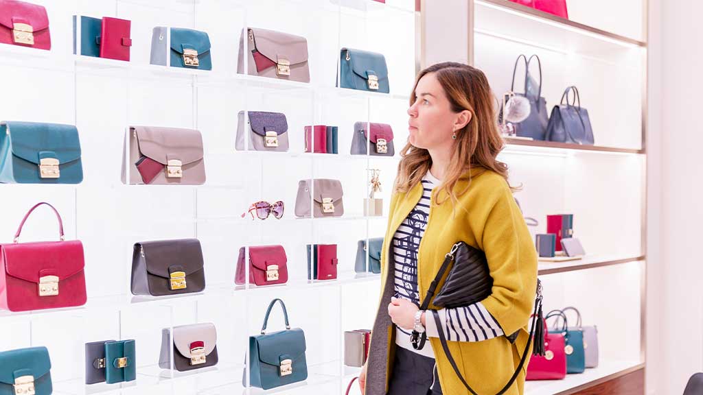 A woman is choosing Fake Designer Bags from multiple bags